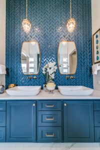 Luxury custom bathroom with blue backsplash and chandeliers