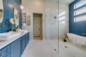 Luxury bathroom with blue backsplash, white countertop, and blue cabinets