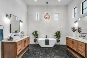 Contemporary bathroom with white tile backsplash, black honeycomb floor, and marble counters.